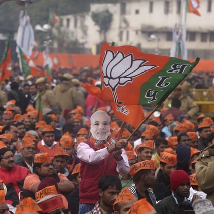 A man wearing a mask of Indian Prime Minister Narendra Modi waves a flag of his Hindu nationalist Bharatiya Janata Party during a rally in December 2019. Photo: AP