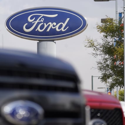 In this Oct. 11, 2020, file photo, the Ford logo hangs over a row of 2020 F-150 pickup trucks in Denver. Photo: AP 