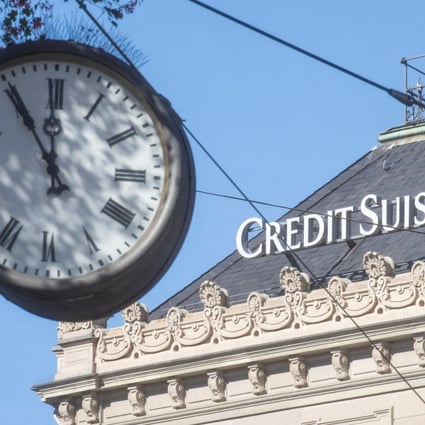 A clock is seen near the logo of Swiss bank Credit Suisse at the Paradeplatz square in Zurich om October 5. Photo: Reuters