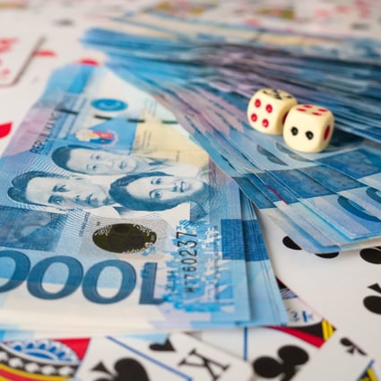Pesos on a pile of playing cards. Thousands of Chinese people working in the Philippines’ gambling sector may have to leave. Photo: Shutterstock