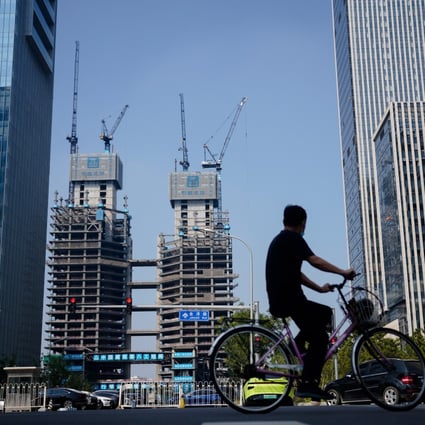 A man bicycles past housing properties in Beijing on September 15, 2022. Real estate and private debt have become increasingly popular among investors for diversification and hedging against risk in the public markets. Photo: EPA-EFE