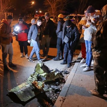 People gather around remains of a military plane that crashed into a residential building in the city of Irkutsk, Russia. Photo: Reuters