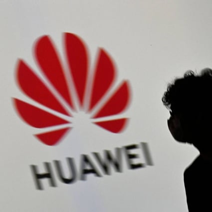 A visitor walks past the Huawei logo on a screen during an electronics trade show in Berlin in September 2020. Photo: AFP
