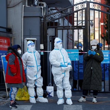 Security personnel in protective suits stand outside a residential compound under lockdown on October 22 as outbreaks of Covid-19 continue in Beijing. Photo: Reuters