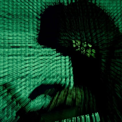 A man holds a laptop computer as cyber code is projected on him in this illustration picture taken on May 13, 2017. Photo: Reuters