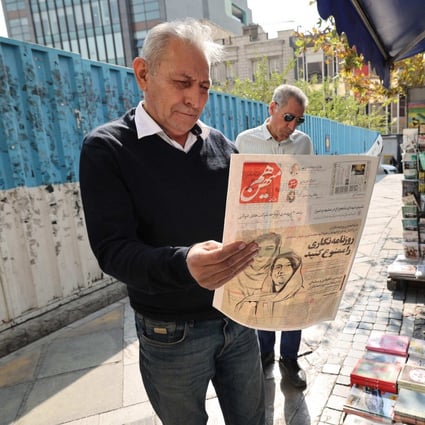 A man in the Iranian capital Tehran reads a copy of the Hammihan newspaper, on October 30, featuring on its cover a headline mentioning the statement by the Tehran journalists’ association, criticising the detention by authorities of two journalists, Niloufar Hamedi and Elaheh Mohammadi (drawing on cover), who according to local media, helped publicise the case of Masha Amini. Photo: AFP
