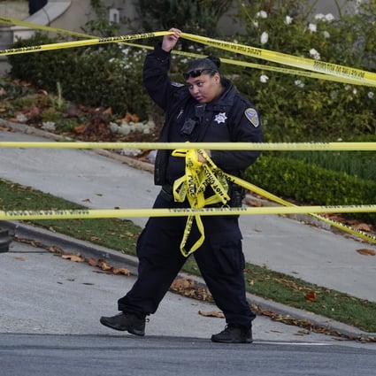 A police officer rolls out more yellow tape below the home of House Speaker Nancy Pelosi and her husband Paul Pelosi in San Francisco. Photo: AP