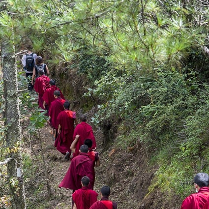 Hikers and monks walk along the Trans Bhutan Trail to mark its reopening. The 400km route linking villages in the kingdom fell into disrepair when it started building roads, but has been restored. Photo: Tim Pile