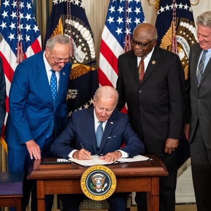 As several legislators looked on, US President Joe Biden signed the Inflation Reduction Act on August 16. Photo: Los Angeles Times/TNS