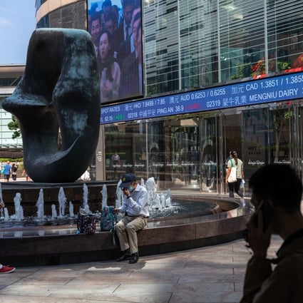 Pedestrians walk past a stock ticker displaying the Hang Seng Index in Hong Kong on October 11, 2022. Photo: EPA-EFE