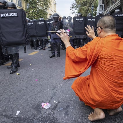 A monk raises his hands as police move to disperse protesters trying to march to the Apec summit venue on November 18 in Bangkok. Photo: AP