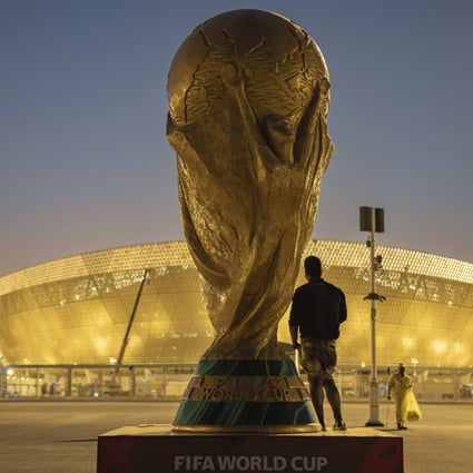 A man with a replica of the World Cup outside Lusail Stadium ahead of the World Cup. Photo: Reuters