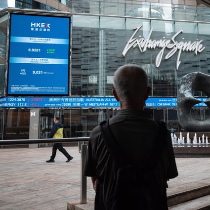 A man looks at electronic boards displaying the Hang Seng Index figure in Hong Kong in August 2022. Photo: EPA-EFE