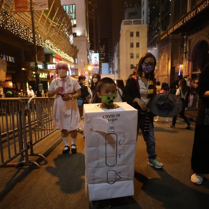 A child dresses up as an RAT test as part of Halloween celebrations in Lan Kwai Fong on October 30. Arrivals into Hong Kong now have to do two PCR tests and seven RAT tests. Photo: Xiaomei Chen