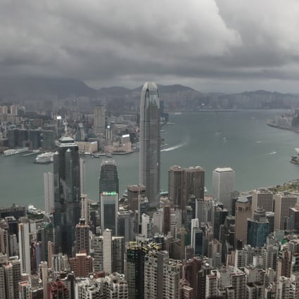 FILE - A visitor sets up his camera in the Victoria Peak area to photograph Hong Kong’s skyline, Sept. 1, 2019. A tropic storm and absences of VIP guests have cast a shadow over Wednesday’s planned financial conference meant to help Hong Kong restore its image as a financial hub and destination for business travel. (AP Photo/Jae C. Hong, File)