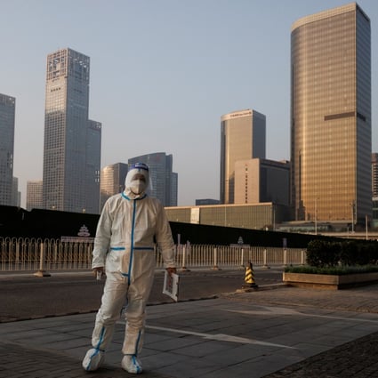 An epidemic prevention worker in a protective suit guards the entrance to an office building in the Beijing central business district as outbreaks of the coronavirus disease continue in China’s capital, Photo: Reuters