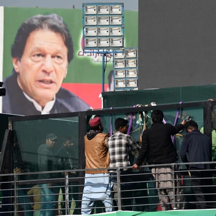 Workers install a bullet-proof glass shield on the main stage ahead of a rally lead by former Pakistan Prime Minister Imran Khan. Photo: AFP