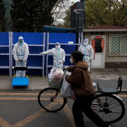 A woman delivers food to a residential compound under lockdown on Monday as Covid-19 outbreaks continue in Beijing. Photo: Reuters