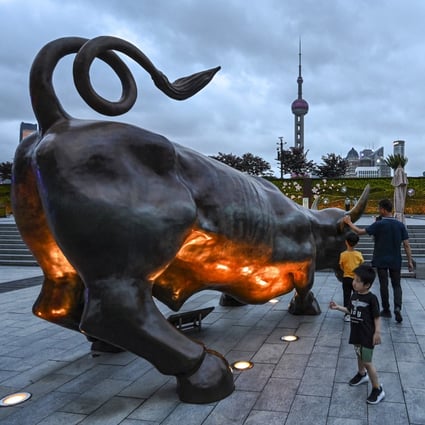 People standing next to the bull sculpture on the Bund in Shanghai. Photo: AFP