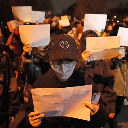Protesters hold up blank papers and chant slogans as they march in protest in Beijing last Sunday. Photo: AP Photo