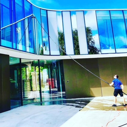 A cleaner for LA Elite Window Cleaning washes the exterior of a mega-mansion in Bel-Air, Los Angeles. Photo: Facebook / LA Elite Window Cleaning