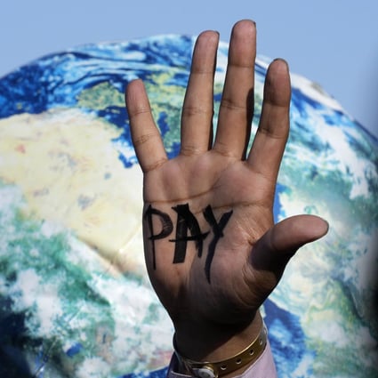 A hand reads “pay” calling for reparations for loss and damage due to climate change at the COP27 UN climate summit on November 18 in Sharm el-Sheikh, Egypt. Photo: AP 