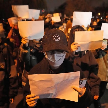 Protesters hold up blank papers in a protest in Beijing on Sunday. Photo: AP