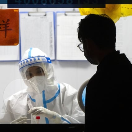 A worker in a protective suit waits to administer Covid-19 tests in Beijing in November. Photo: AP