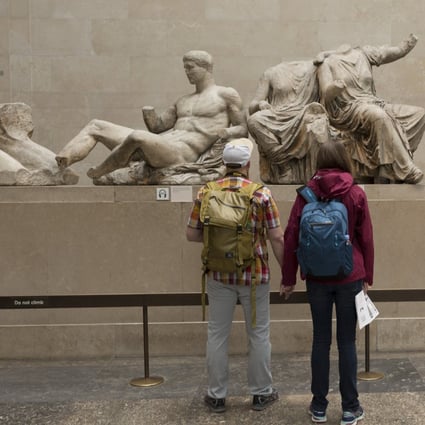 Visitors admire the sculpture of the ancient Greek Parthenon’s Elgin Marbles Metopes in the British Museum. Photo: Getty Images