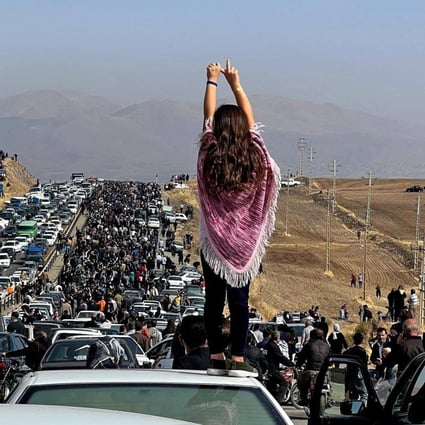 This UGC image posted on Twitter reportedly on October 26, 2022 shows an unveiled woman standing on top of a vehicle as thousands make their way towards Aichi cemetery in Saqez, Mahsa Amini’s home town in the western Iranian province of Kurdistan, to mark 40 days since her death, defying heightened security measures as part of a bloody crackdown on women-led protests. Photo: UGC/AFP