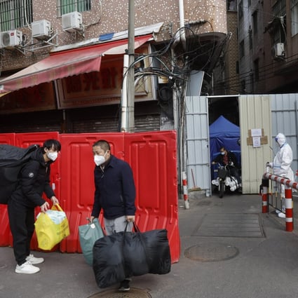 Migrant workers leave a barricaded village after  Covid-19 curbs are eased in  Haizhu district in Guangzhou in southern China. Photo: AP