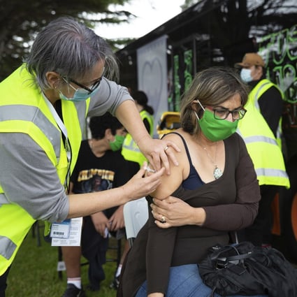 A health worker administers a Covid-19 vaccination to a woman in Auckland, New Zealand, last year. Photo: New Zealand Herald via AP