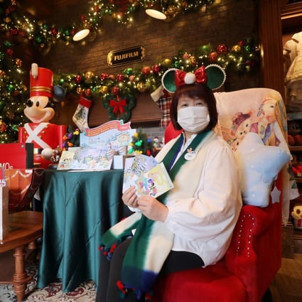 Mary Lam, the director of merchandise at Hong Kong Disneyland Resort, shows off some of the charity postcards available to support Operation Santa Claus. Photo: Xiaomei Chen
