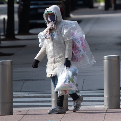 A person wrapped in plastic walks outside the headquarters of the International Monetary Fund during the onset of the Covid-19 pandemic in Washington on April 15, 2020. Photo: AFP