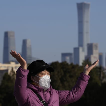 A woman poses for a photo in the Temple of Heaven Park, in Beijing, with the city skyline in the background, on December 8. Photo: AP