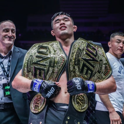 Christian Lee holds his two ONE Championship title belts after beating Kiamrian Abbasov. Photo: ONE Championship