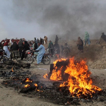 People gather near flaming wreckage caused by Afghan Taliban forces’ mortar fire in Pakistan’s border town of Chaman on Sunday. Photo: AFP