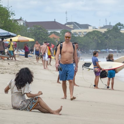 An older Westerner walks along a beach in Bali. Indonesia hopes its new second-home visa programme will entice billionaires and millionaires, but the retirees already living there feel like they’ve been left in the lurch. Photo: EPA-EFE