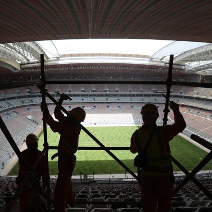 Labourers remove scaffolding at the Al Bayt stadium in Al Khor, Qatar on April 29, 2019. Migrant labourers who built Qatar’s World Cup stadiums often worked long hours under harsh conditions and were subjected to discrimination, wage theft and other abuses, a rights group said. Photo: AP