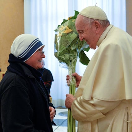 Pope Francis receives flowers from a nun during his 86th birthday celebrations. Photo: Reuters