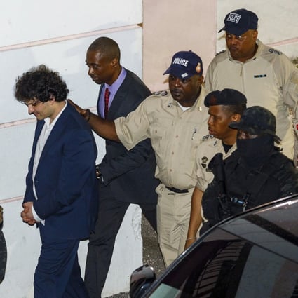 Samuel Bankman-Fried, centre, is escorted out of the Magistrate Court building the day after his arrest in Nassau, Bahamas, on December 13, 2022. Photo: AP