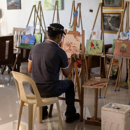 Filipino artist Elito Circa, 52, paints using his blood in his studio in Nueva Ecija province, Philippines. Photo: Reuters