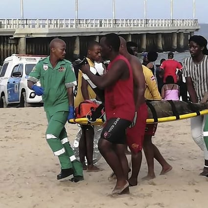 Paramedics carry a person on a stretcher on the Bay of Plenty Beach in Durban, South Africa on Saturday. Photo: AP
