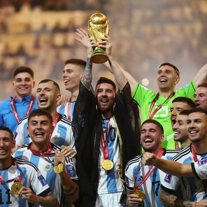 Lionel Messi lifts the World Cup trophy alongside teammates as they celebrate their victory. Photo: Reuters