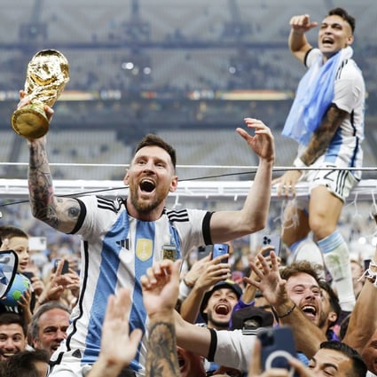 Lionel Messi celebrates while holding the World Cup trophy after his side’s penalty shootout win over France. Photo: Kyodo