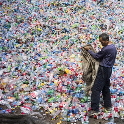 A worker sorts plastic bottles for recycling on the outskirt of Beijing. The recycling of steel, aluminium, plastic and paper, four carbon-intensive commodities, is expected to contribute to a total reduction of 670 million tonnes of carbon dioxide emissions this year, Miotech says. Photo: AFP