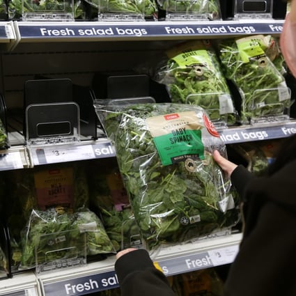 A customer looks at baby spinach in a supermarket in Sydney. Australians who ate contaminated spinach have described feeling dizzy or unable to stand, having blurred vision, and struggling to breathe normally. Photo: Xinhua