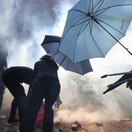 Protesters try to extinguish tear gas canisters fired by police during the 2019 PolyU anti-government protest. Photo: Winson Wong