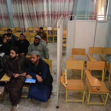 Male students in Kandahar Province attend a university class, where a curtain normally would separate them from women, who have now been banned. Photo: AFP