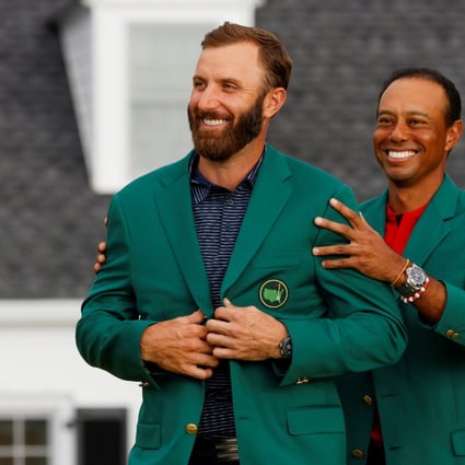 Dustin Johnson is presented with the green jacket by Tiger Woods after winning The 202 Masters. Photo: Reuters